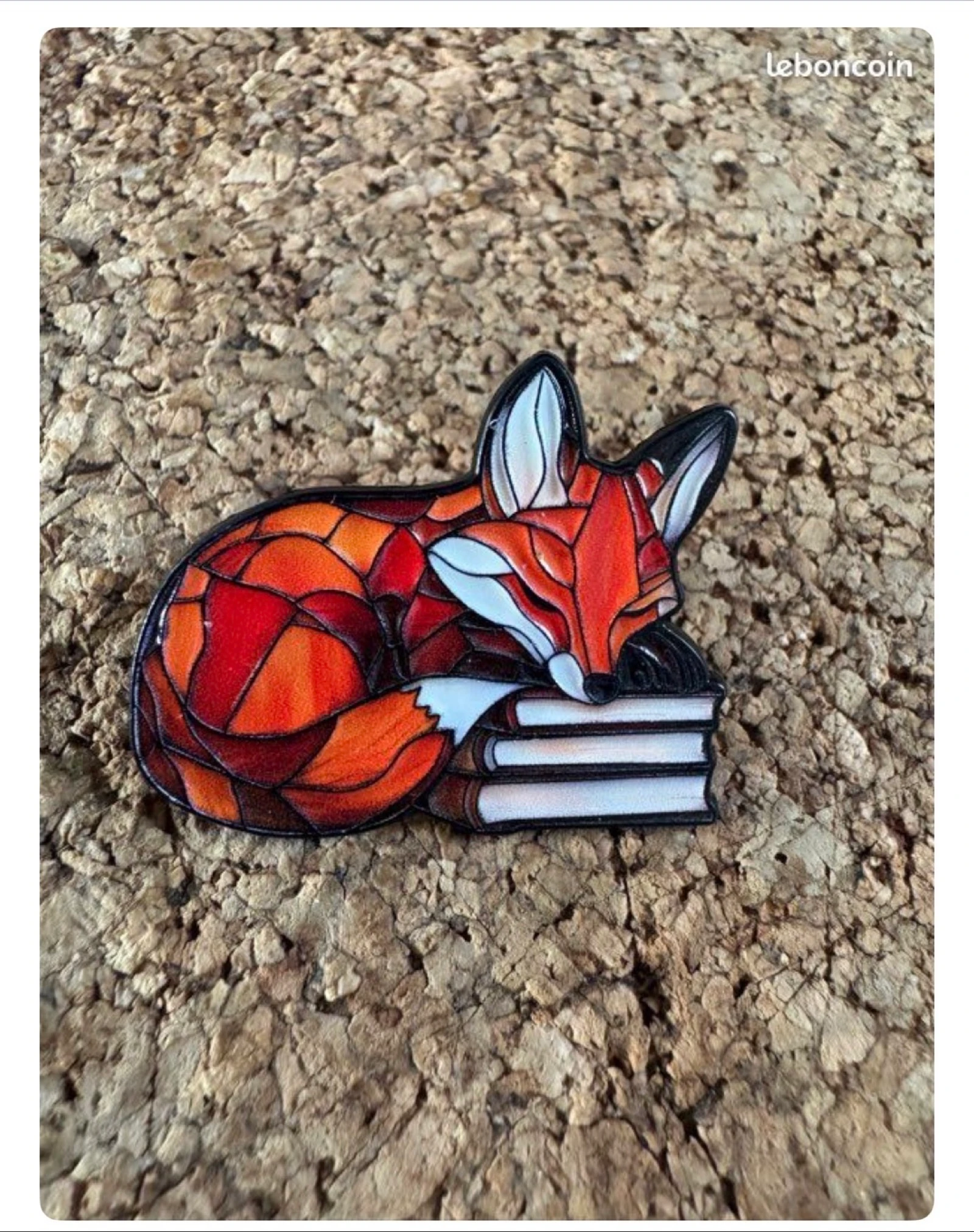 Pin’s renard endormi sur les livres 